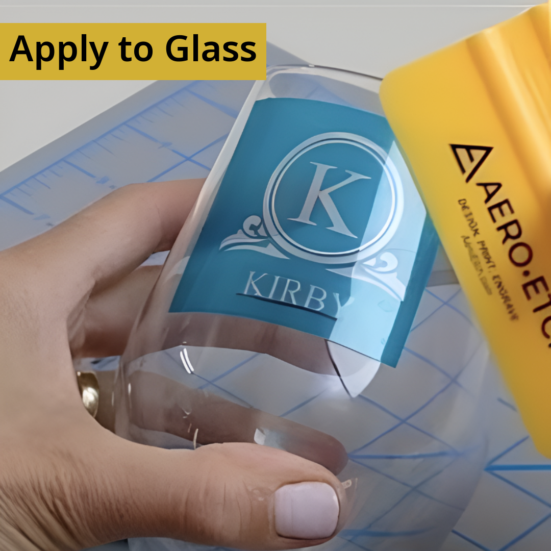 Person applying Aero-Etch sand-carving stencil to glass tumbler.