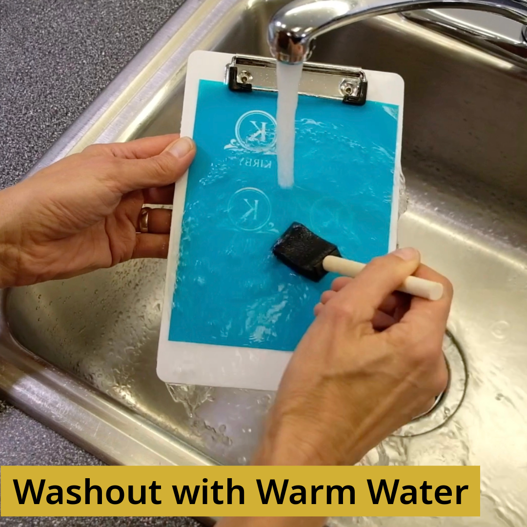 Person developing Aero-Etch sandcarving stencils during washout process.
